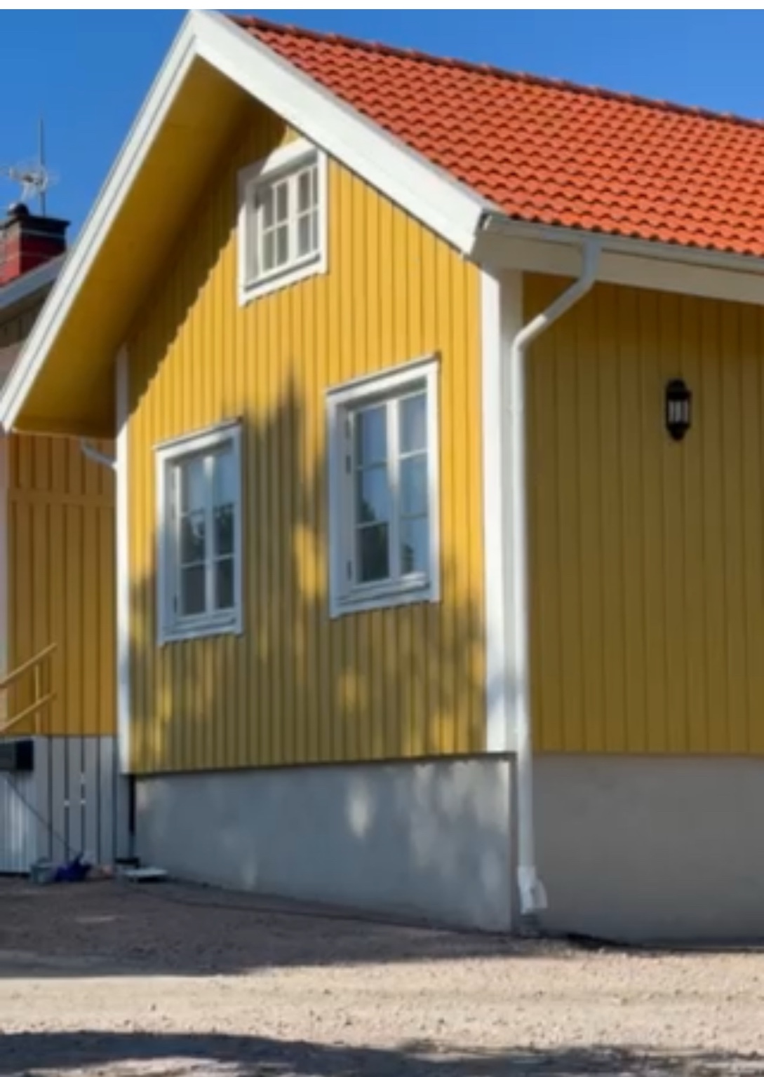 Nymålat gult trähus med vita detaljer